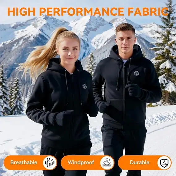 A man and a woman in black Changeown zip hoodies and gloves standing in snow in front of mountains
